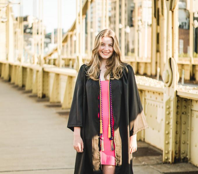 Photo of Laura smiling while wearing graduation gown